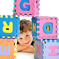 child learning to read with letter blocks